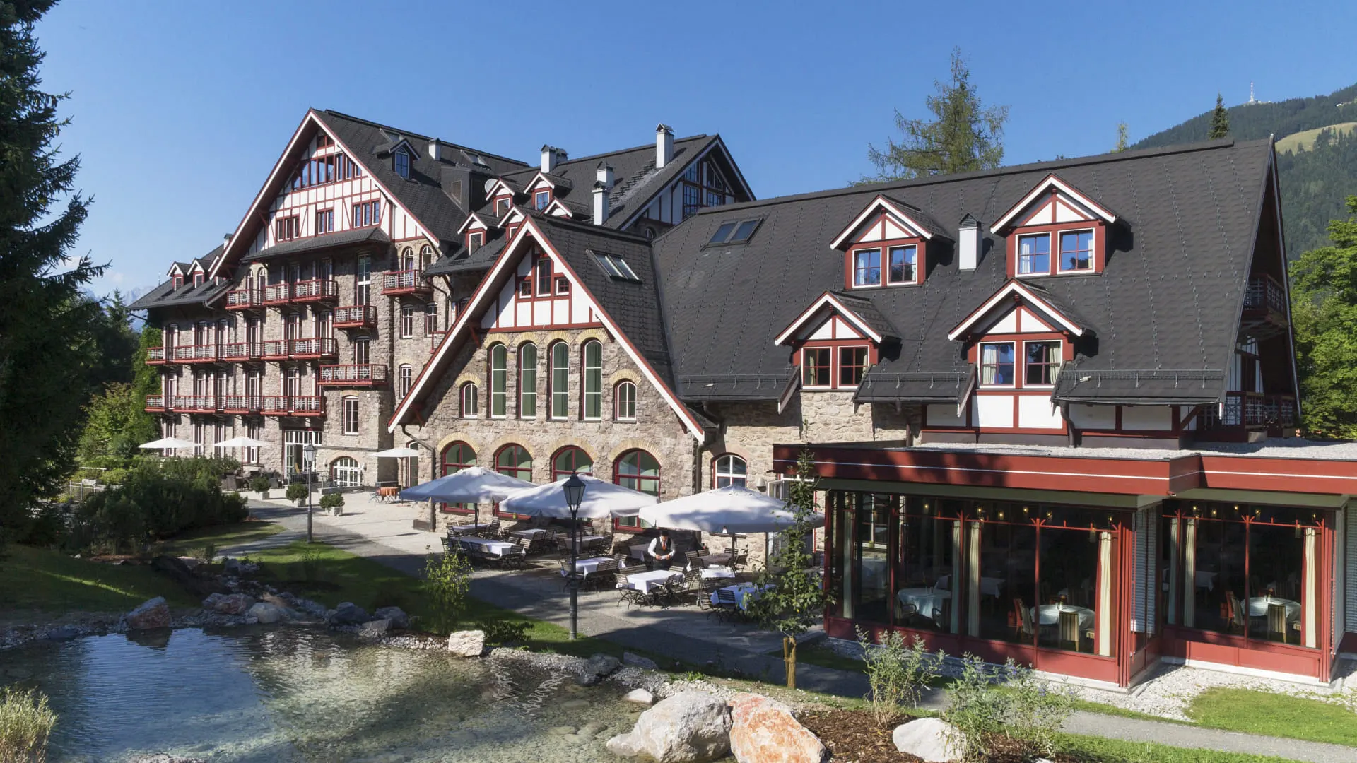 View of Grand Hotel Kitzbühel with garden and water feature